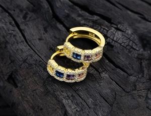 Macro detail of 925 sterling silver hoop earrings with multicolor gemstones and gold plating