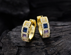 Macro shot of 925 silver gold-plated hoop earrings with multi-colored gemstones detail