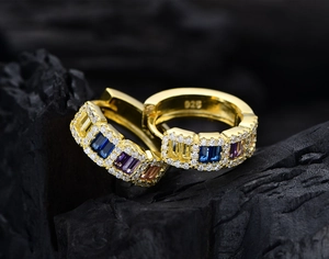 Macro shot of 925 silver gold-plated hoop earrings with multicolor rectangular stones