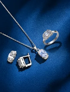 Detailed view of 925 sterling silver jewelry set with oval zirconia on blue fabric