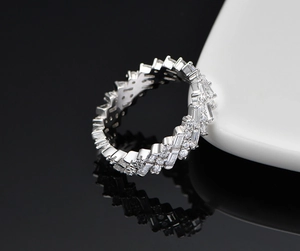 Détail macro d'une bague en argent S925 avec des rangées entrelacées de zircons baguettes et ronds