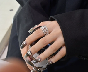 Gros plan d'une bague large en argent S925 ajourée de fleurs et zircons blancs