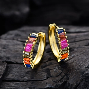 Gold hoop earrings featuring vibrant rectangular multi-color zircons on dark wood background