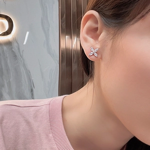 Elegant silver four-leaf clover stud earrings with marquise-cut zircons on a model