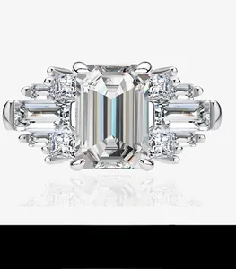 Macro detail of emerald cut gemstone ring with step-cut side stones and silver band