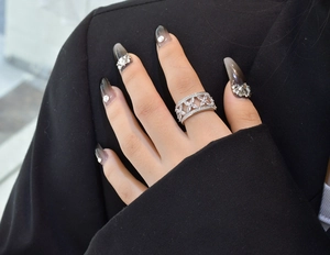 Détail d'une large bague en argent S925 évidée avec fleurs en zircon sur un doigt