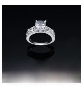 Macro view of square cut high carbon diamond ring with side accent stones on black mirror