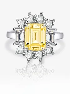 Vue macro de bague en diamant jaune taille émeraude avec monture halo en argent