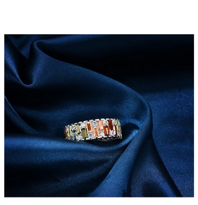 Macro shot of colorful rectangular gemstones and round cubic zirconia on silver band