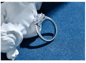 Detailed view of an oval-cut gemstone ring set against a blue textured background