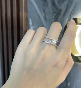 Close-up of double layer silver ring featuring a round pearl and oval zircon stones
