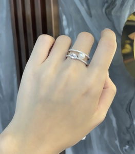 Detail of 925 sterling silver stacked rings with white pearl and pear-cut gemstone
