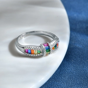 S925 sterling silver rainbow ring with colorful zircon stones on a white ceramic plate