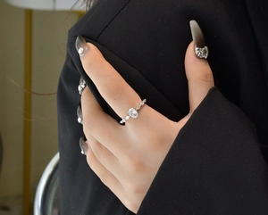 Detailansicht eines silbernen Rings mit ovalem Stein und Marquise-Diamanten am Finger