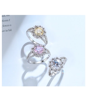 Détail de trois bagues en argent S925 serties de pierres jaunes, roses et blanches de style halo