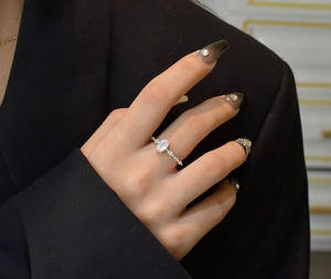 Detailansicht eines Rings mit ovalem Edelstein und Marquise-Akzenten an der Hand