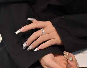 Détail d'une bague en argent S925 avec zircons rectangulaires et nail art à nœud papillon