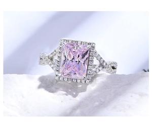 Macro detail of radiant cut pink stone ring with halo setting and twisted pavé band