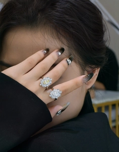 Close-up of S925 silver rings with yellow marquise cut stone and halo diamonds on model