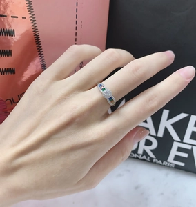 Close-up of a silver ring with rainbow gemstones and micro-pave center worn on finger