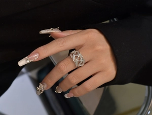 Vue rapprochée d'une bague large ajourée en argent avec zircons sur tissu noir