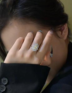 Close-up of vintage s925 silver ring with marquise yellow stone and diamond halo on finger