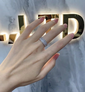 Close-up of double-row micro-pave sterling silver ring worn by a model on marble