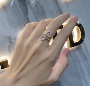 Close-up of double heart sterling silver ring with micro-pave cubic zirconia on finger