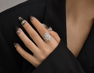 Close-up of S925 silver ring with yellow marquise gemstone on hand against black suit