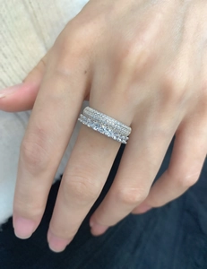 Close-up of stacked 925 silver rings with double-row micro-pave and large zircon stones