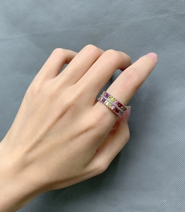 Close-up of double-row rainbow gemstone eternity ring featuring multicolor baguette-cut stones