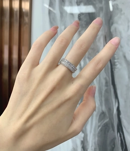 Close-up of double row micro-paved 925 sterling silver rings stacked on a finger