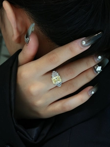Macro detail of radiant yellow gemstone ring in 925 silver with side accent diamonds