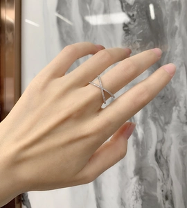 Detail of S925 sterling silver ring featuring a criss-cross X design with cubic zirconia