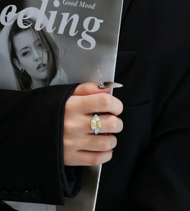 Macro shot of S925 silver ring featuring a large square yellow stone on a model's finger
