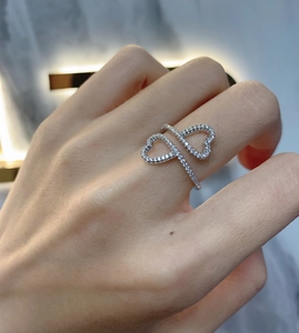 Close-up of interlinked double heart ring in silver with pavé-set white cubic zirconia