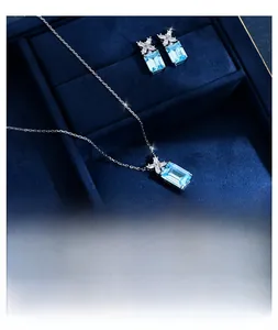 Detail of aquamarine jewelry set with emerald-cut blue stones in a navy velvet box
