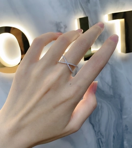 Detailed close-up of s925 silver criss-cross ring with micro-paved white zircons on hand