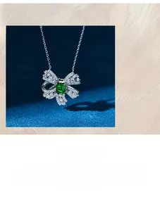 Macro shot of 925 silver bow necklace with emerald cut green zircon and 5A crystals