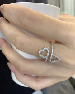 Close-up of silver double heart open ring with micro-paved cubic zirconia on model hand