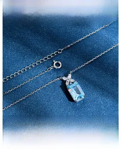 Macro shot of rectangular blue aquamarine pendant with floral silver setting