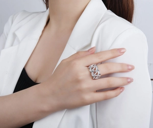 Détail d'une bague large vague en argent avec zircons étincelants portée par un mannequin