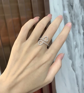 Close-up of interlocking double heart ring with zircon inlay on a model hand