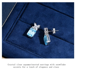 Macro detail of aquamarine stud earring with snowflake diamond accents on velvet