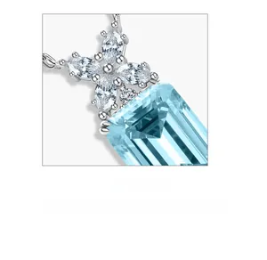 Macro detail of emerald cut aquamarine stone with cluster diamond accents on silver