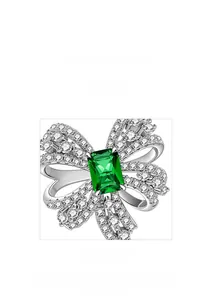 Macro view of emerald bow earring with detailed micro-pave setting on silver