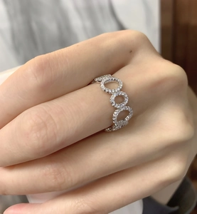 Nahaufnahme der ineinander verschlungenen S925 Silberringe mit Zirkonbesatz am Finger