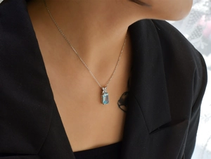 Close-up of elegant aquamarine gemstone necklace with bow detail on female neck