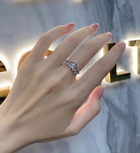 Macro shot of V-shaped S925 silver ring featuring pear-cut center stone on finger