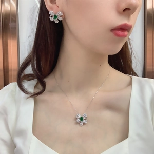 Detail of emerald bow jewelry set with silver finish and pavé zircon on Asian model
